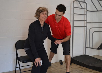Physical therapist aiding an elderly woman