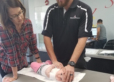 A physical therapist assessing a young infant