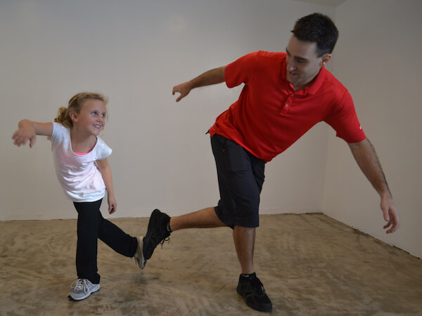 Physical therapist with a young girl practicing standing on 1 leg and body position
