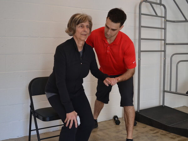Physical therapist helping an elderly woman stand 