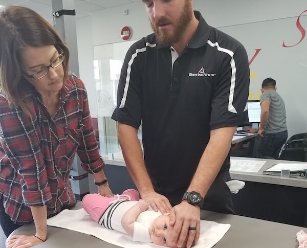 Physical therapist measuring and checking vitals on an infant