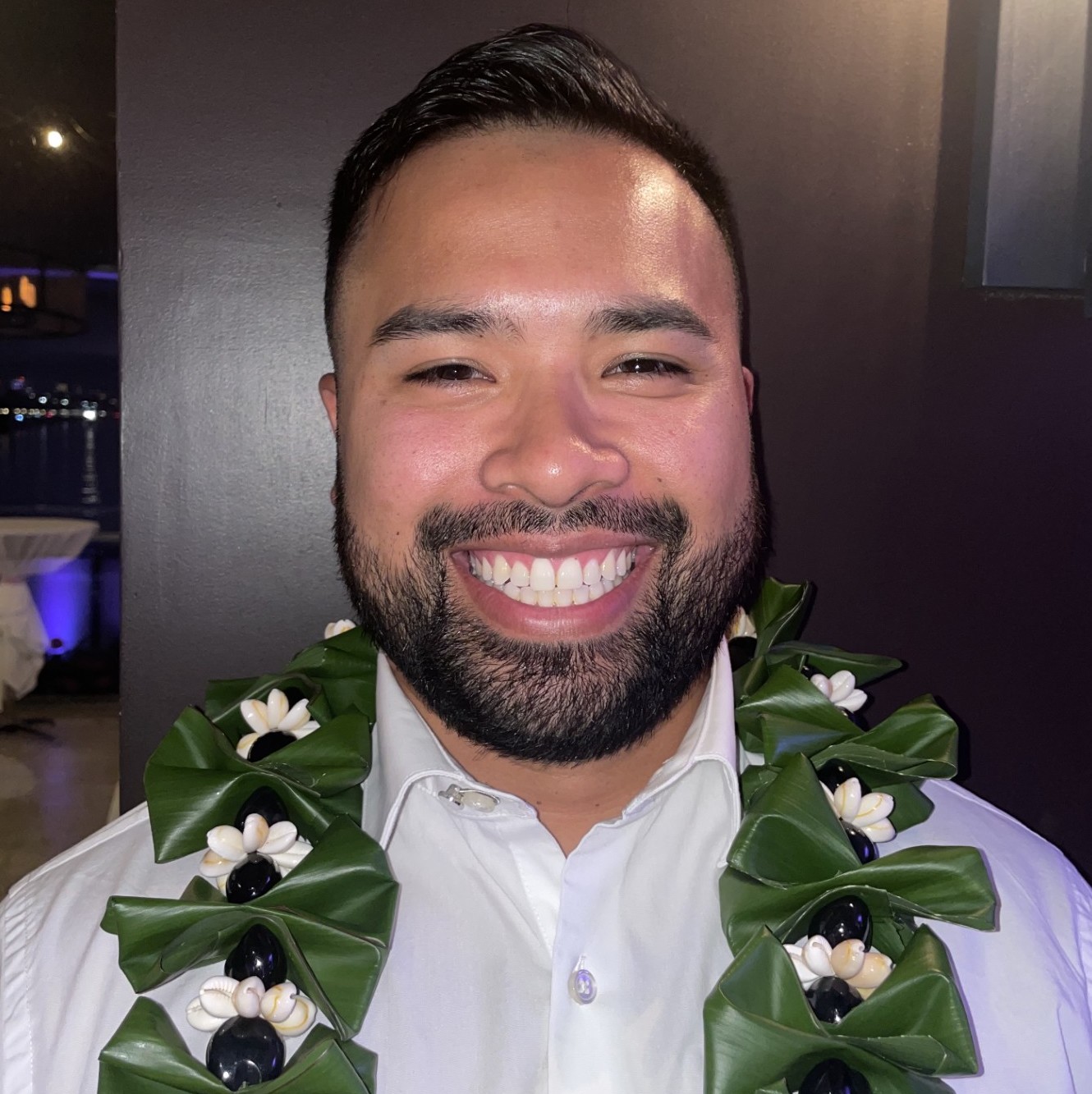 Man with dark hair and a goatee smiling 